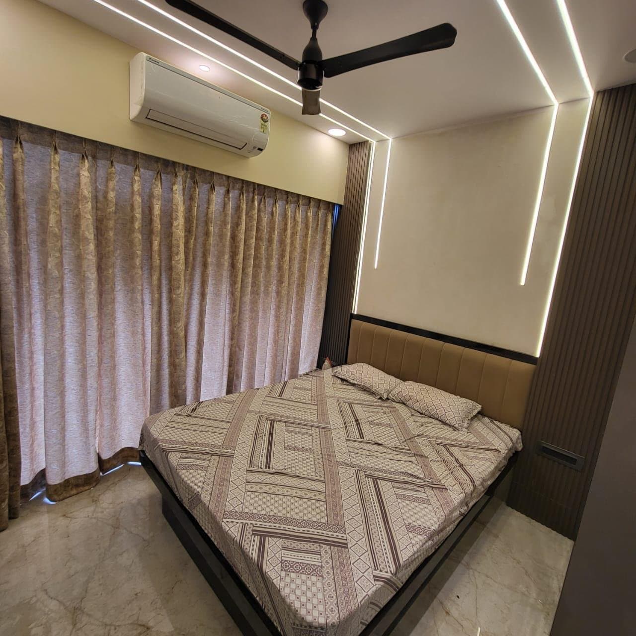 Bedroom with backlit wall panelling above an upholstered bed headboard