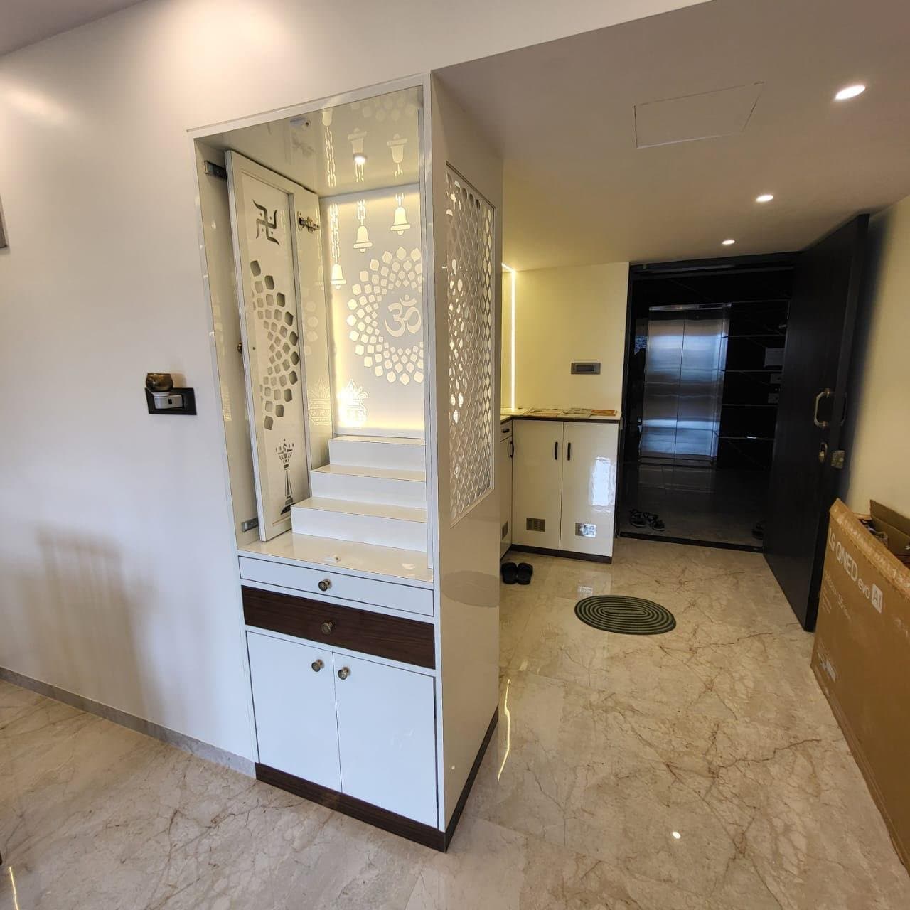 Wide view of a foyer with a custom pooja unit and white storage cabinetry