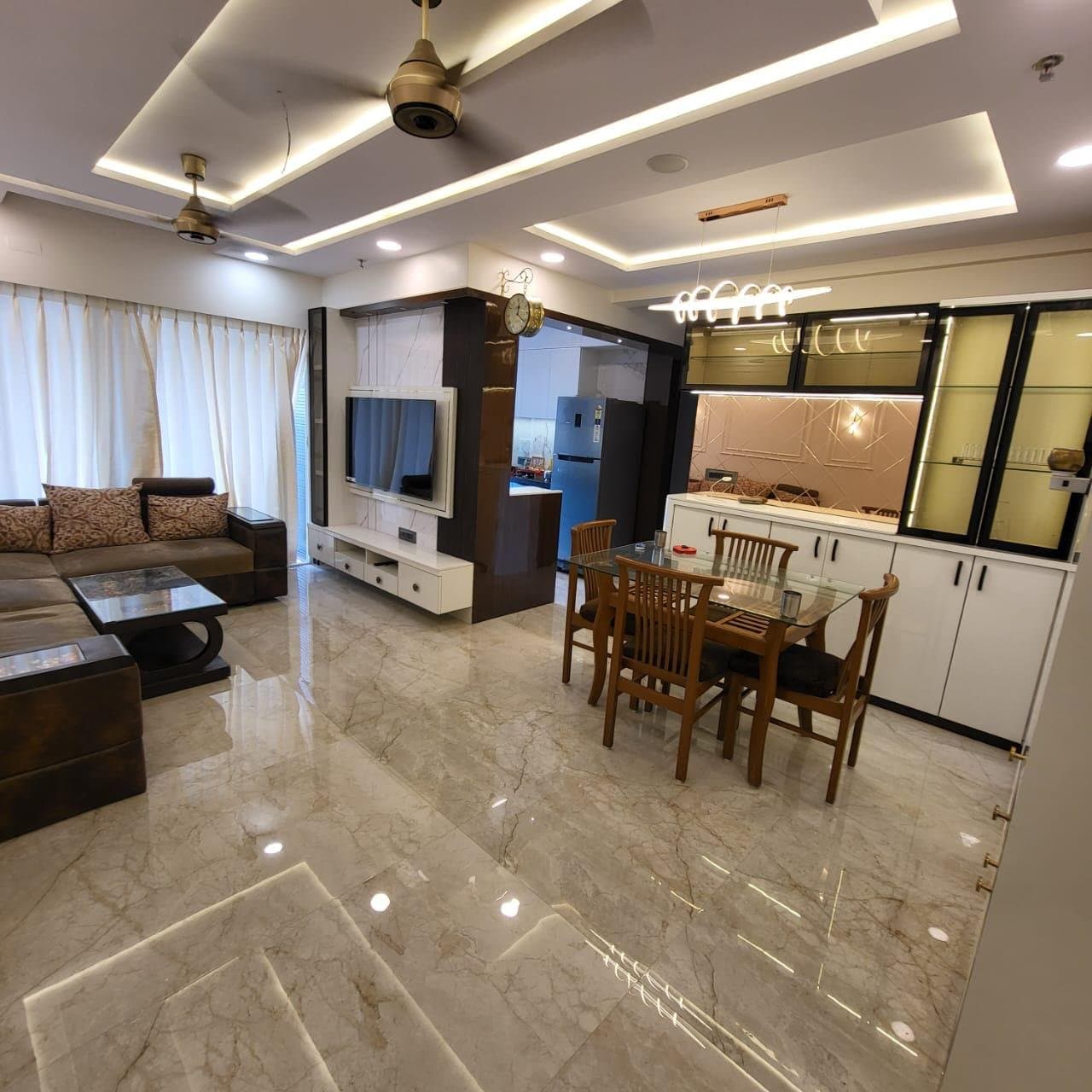 Living and dining area with wooden dining set and view toward the kitchen counters